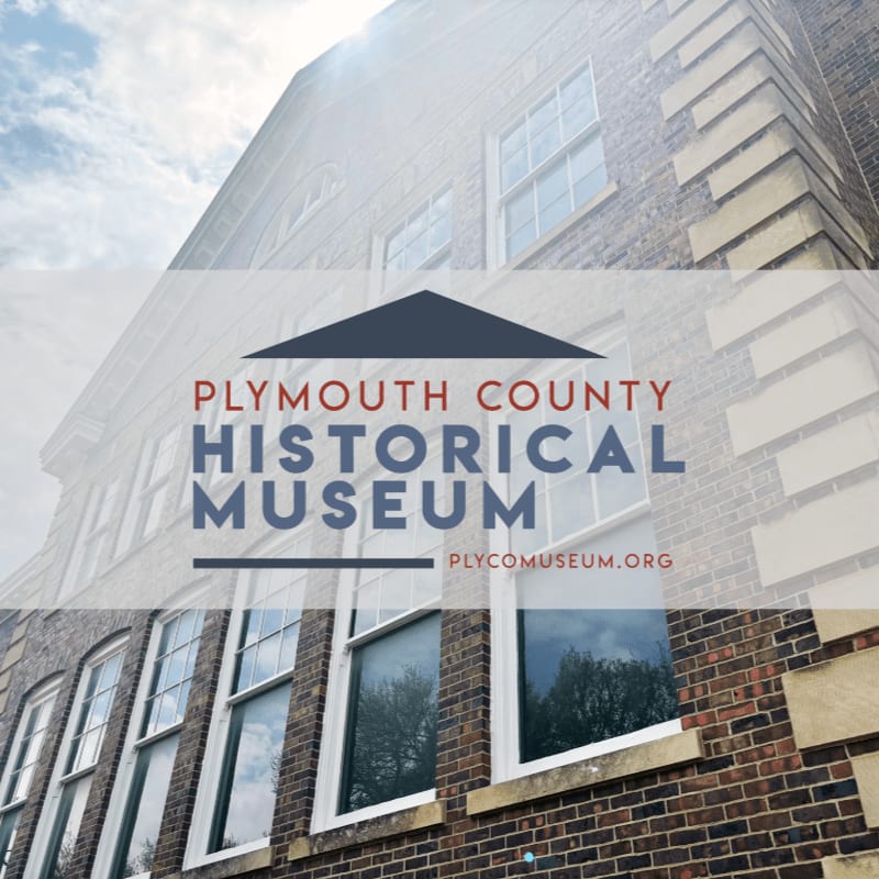 The text "Plymouth County Historical Museum" and its website are overlaid in the foreground against a background of a multi-story brick building under a cloudy sky.