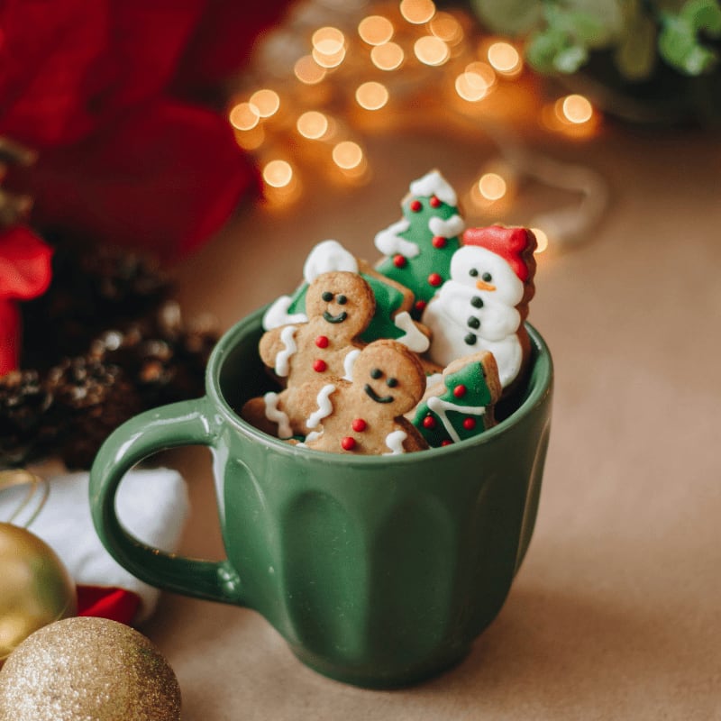 a cup filled with christmas cookies on top of a table