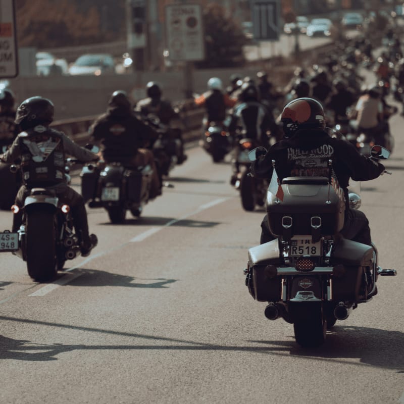 a large group of people riding motorcycles down a street