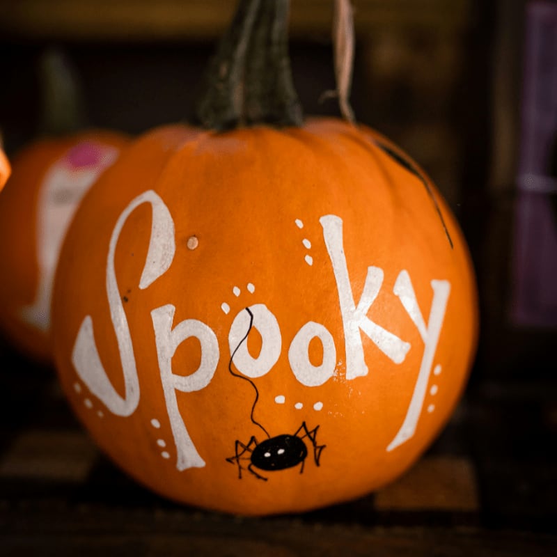 a pumpkin with the word spooky painted on it