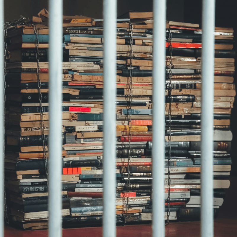 a stack of books behind bars in a room