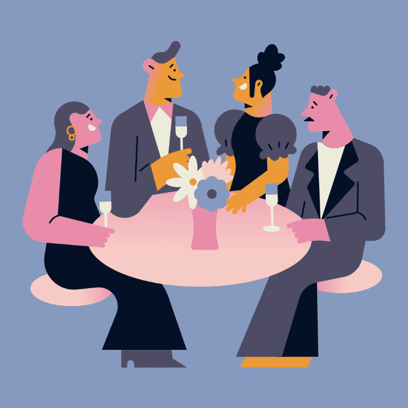 Four people in formal attire sit around a round table with flowers against a solid blue background.