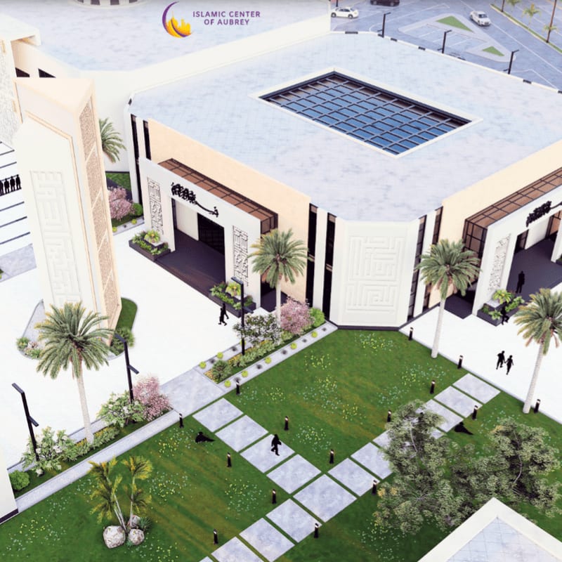A modern white building with a skylight overlooks a landscaped courtyard with green grass, palm trees, and walking paths.