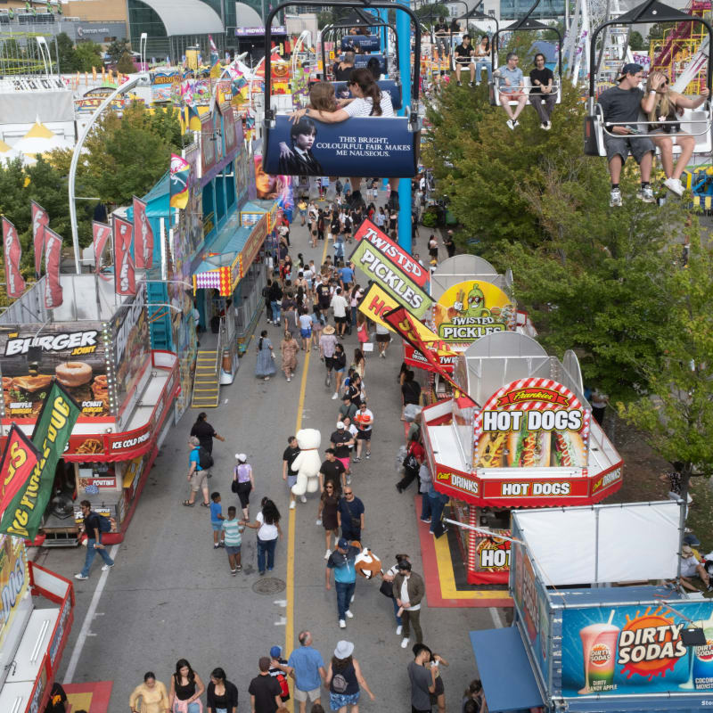 People enjoying a sunny day at a bustling fairground