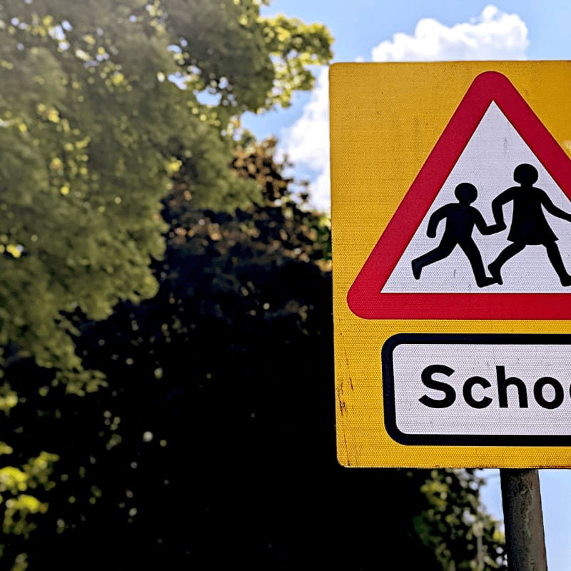 School crossing warning sign with children silhouettes