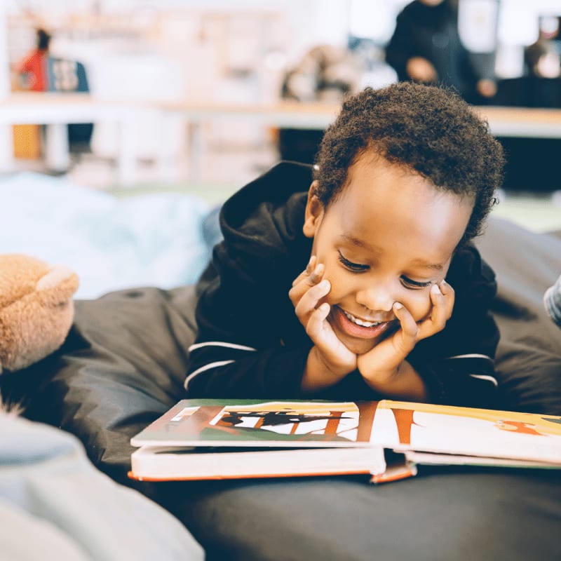 boy smiling and reading book