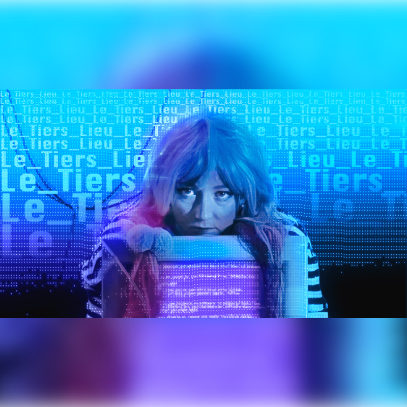 A woman with blue and pink hair looks over a glowing computer monitor against a digital background of repeating blue text.