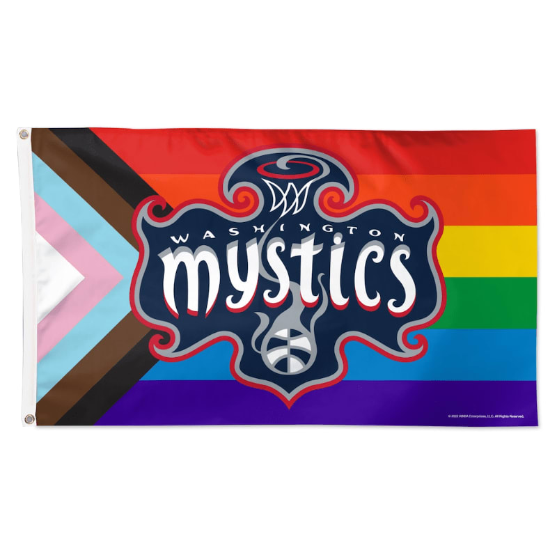 The Washington Mystics logo is centered in the foreground over a background featuring a combination of the rainbow and transgender pride flags.