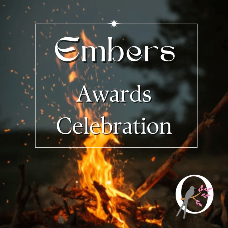A blazing campfire with glowing embers in the foreground sits before a blurred dark forest background, overlaid with a white frame containing the text "Embers Awards Celebration."