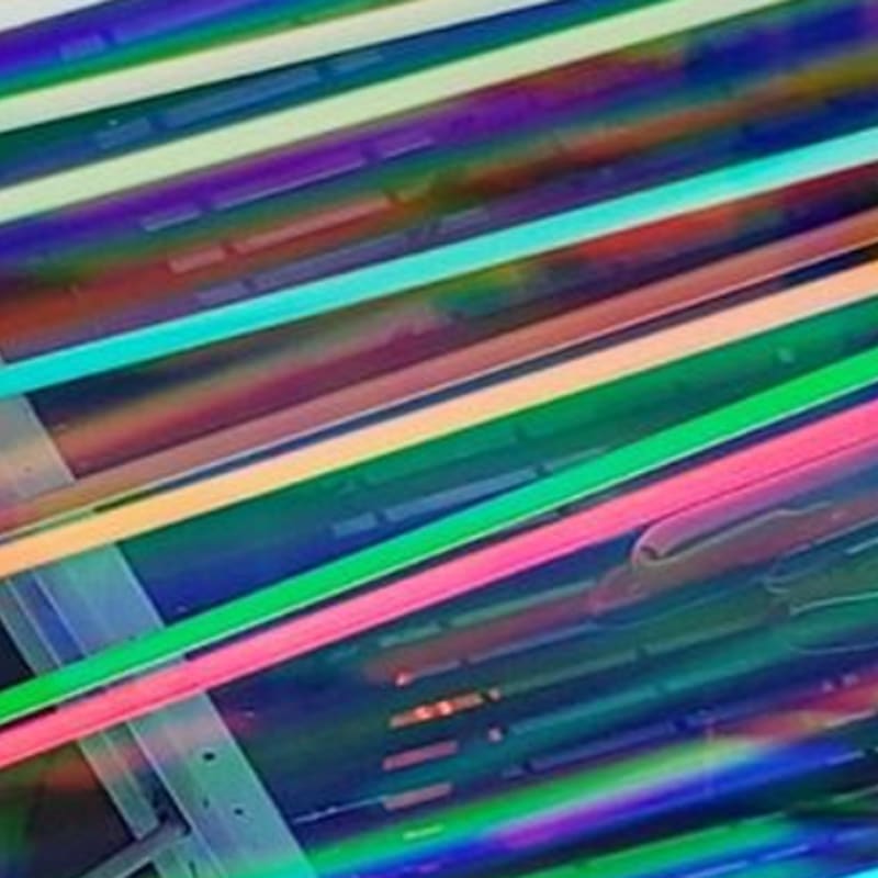 Vibrant, multicolored neon lines stretch diagonally across a dark, iridescent background.
