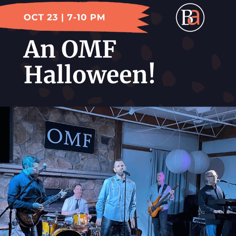 A band performs on a stage with a stone wall and "OMF" sign in the background, beneath a promotional graphic for a Halloween event.