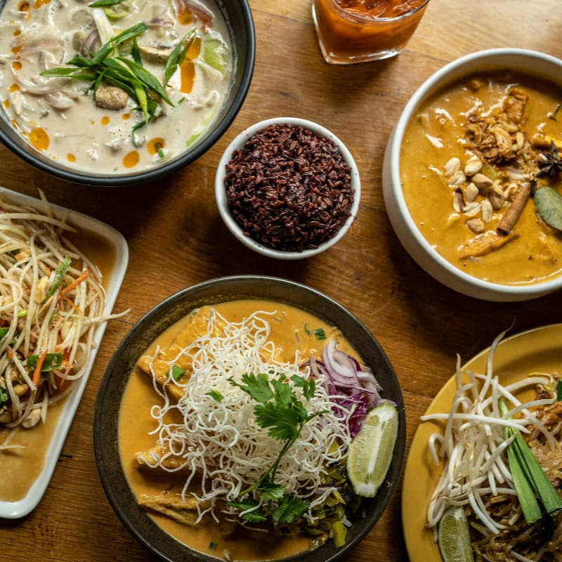 a wooden table topped with plates of food