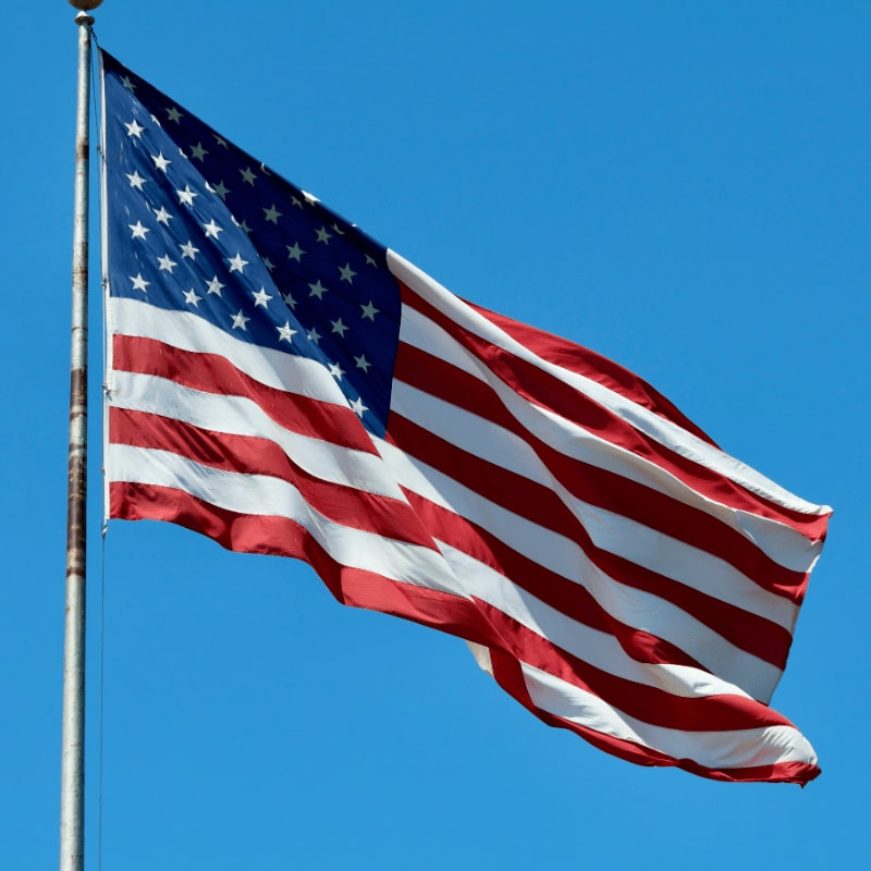 A large american flag flying in the wind