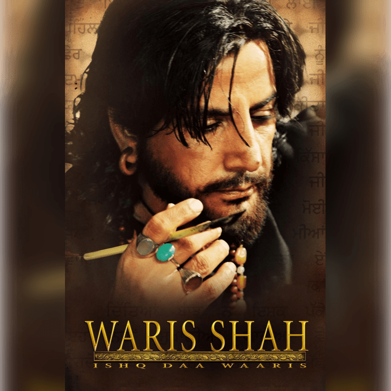 A man with long dark hair and a beard, wearing rings and holding a quill, is positioned in the foreground against a background of faded script.