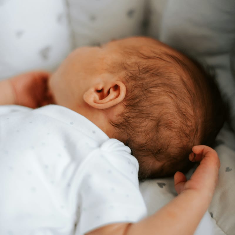 a baby is sleeping in a white crib