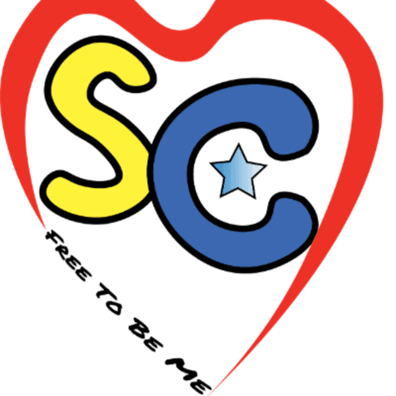 A red heart encloses the letters "SC" in yellow and blue, with a small blue star inside the "C", and the words "FREE TO BE ME" written below.