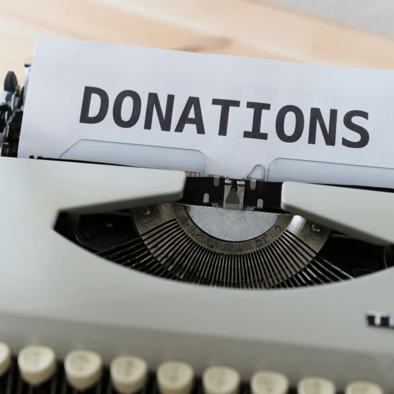 a close up of a typewriter with a donation sign on it