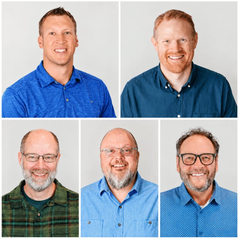 Five smiling men in various blue and plaid shirts are positioned in a grid against a plain light gray background.