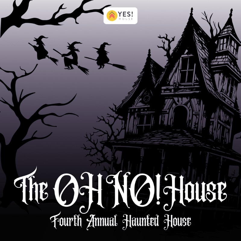 A spooky haunted house and bare trees stand in the foreground against a purple sky with three witches flying on brooms in the background.