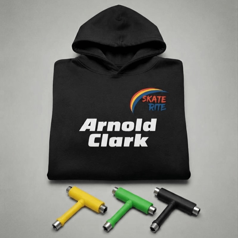 A black hoodie with "Arnold Clark" and "Skate Rite" logos sits behind three colorful T-shaped tools on a plain grey background.