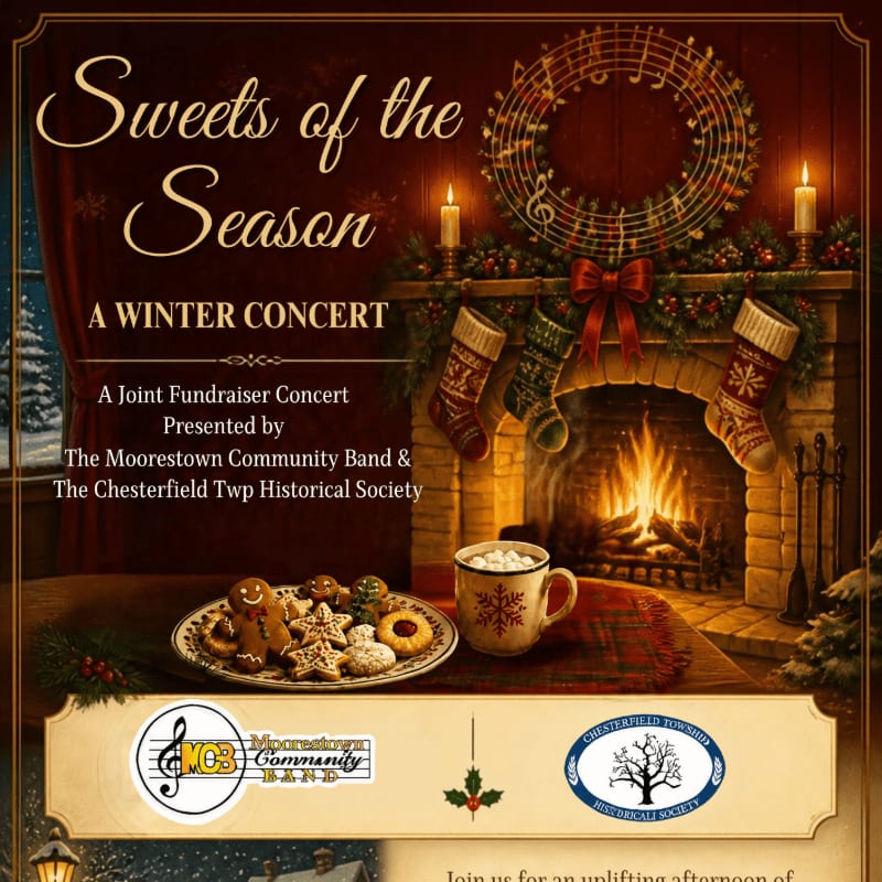 A cozy fireplace scene with a plate of cookies and a mug of cocoa in the foreground, set against a background of a decorated mantel and a festive musical wreath.