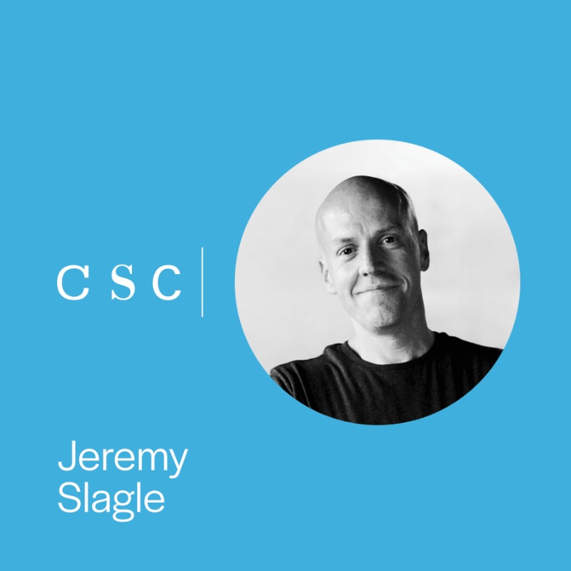 A black and white portrait of Jeremy Slagle in a circular frame is set against a solid blue background featuring the text "CSC" and his name.
