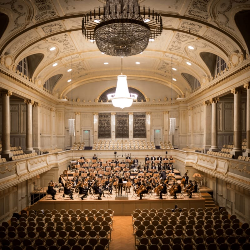 music group performing on stage with empty audience seats