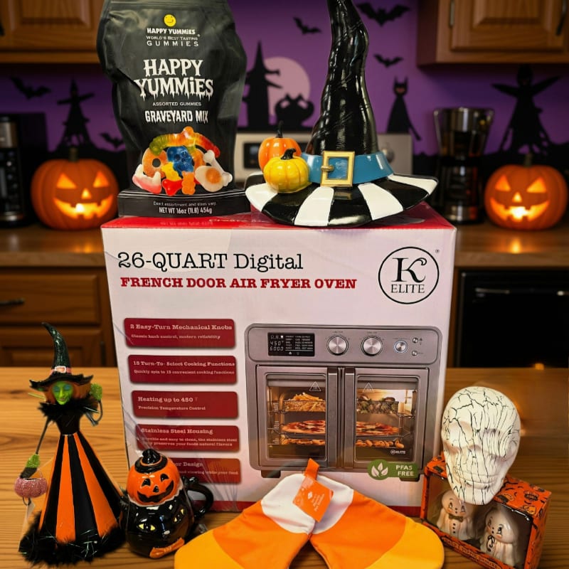 Halloween decorations, a bag of gummy candies, and a witch's hat sit atop a box for a 26-quart digital air fryer oven, set against a purple background with spooky silhouettes.