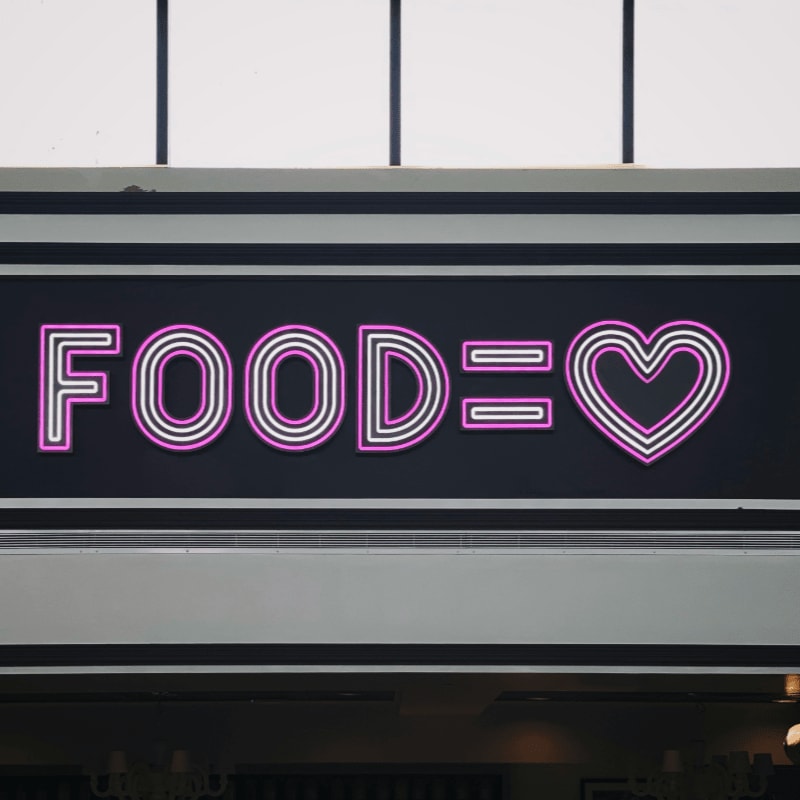 a neon sign that says foodie with a heart