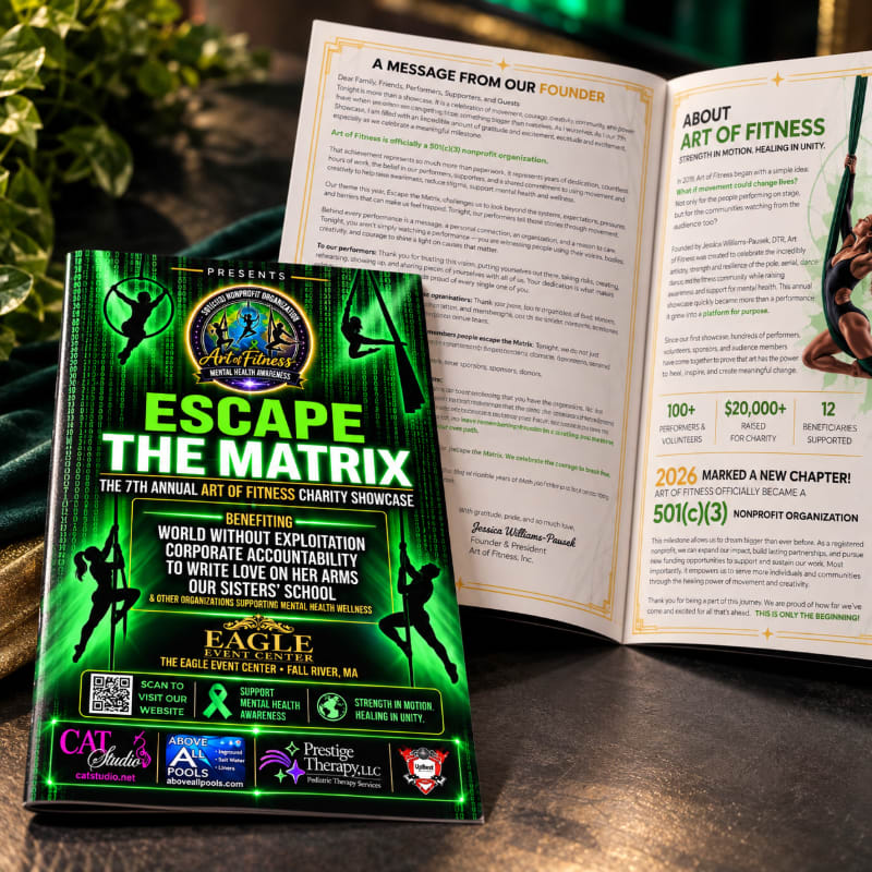 A colorful event flyer for "Escape the Matrix" sits in the foreground, positioned in front of an open brochure on a dark surface.