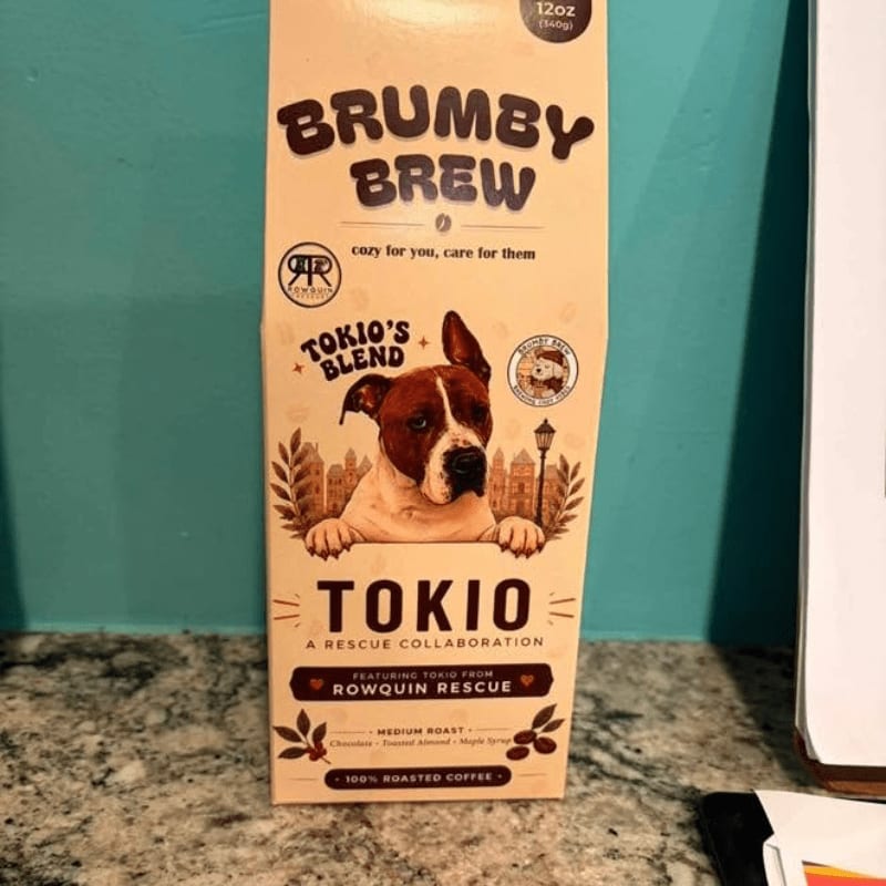 A box of Brumby Brew coffee featuring a dog named Tokio stands on a granite countertop against a teal wall.