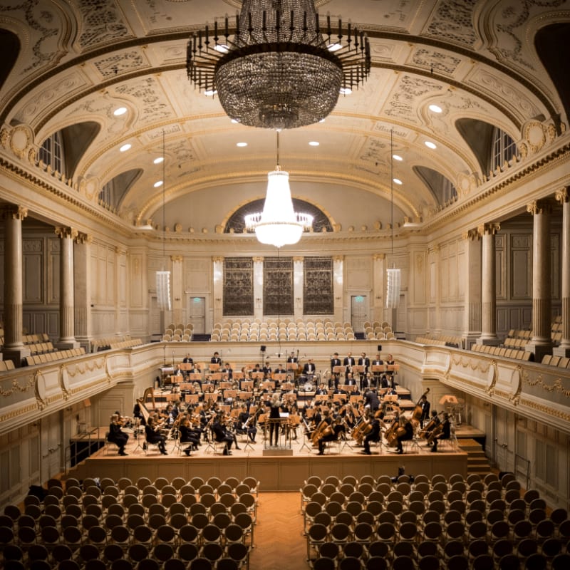 music group performing on stage with empty audience seats