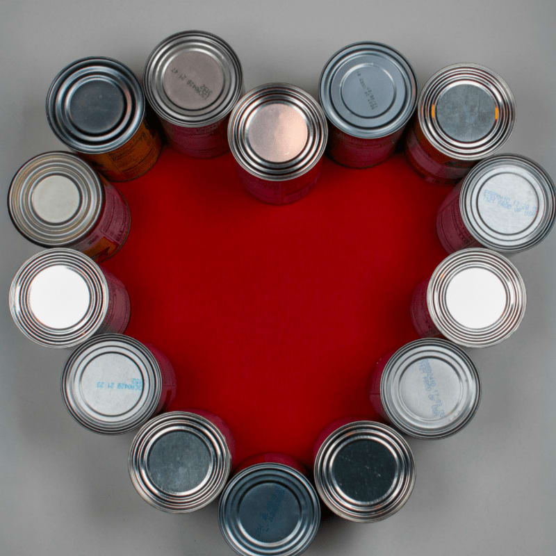 Cans arranged in a heart shape on a red background