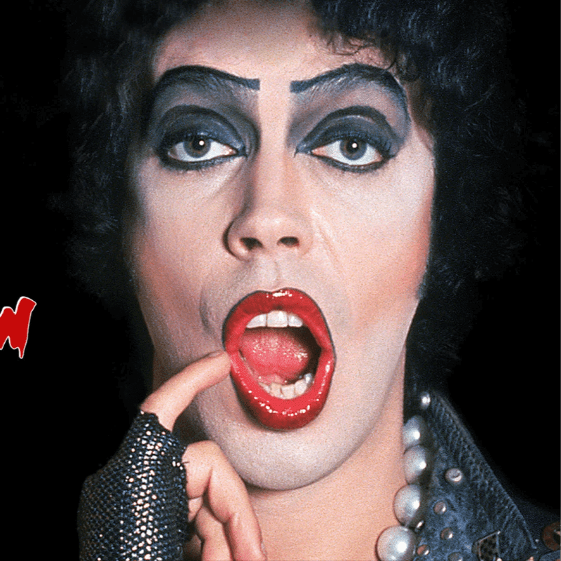 A person with heavy makeup and a finger in their open mouth is positioned against a dark, plain background.