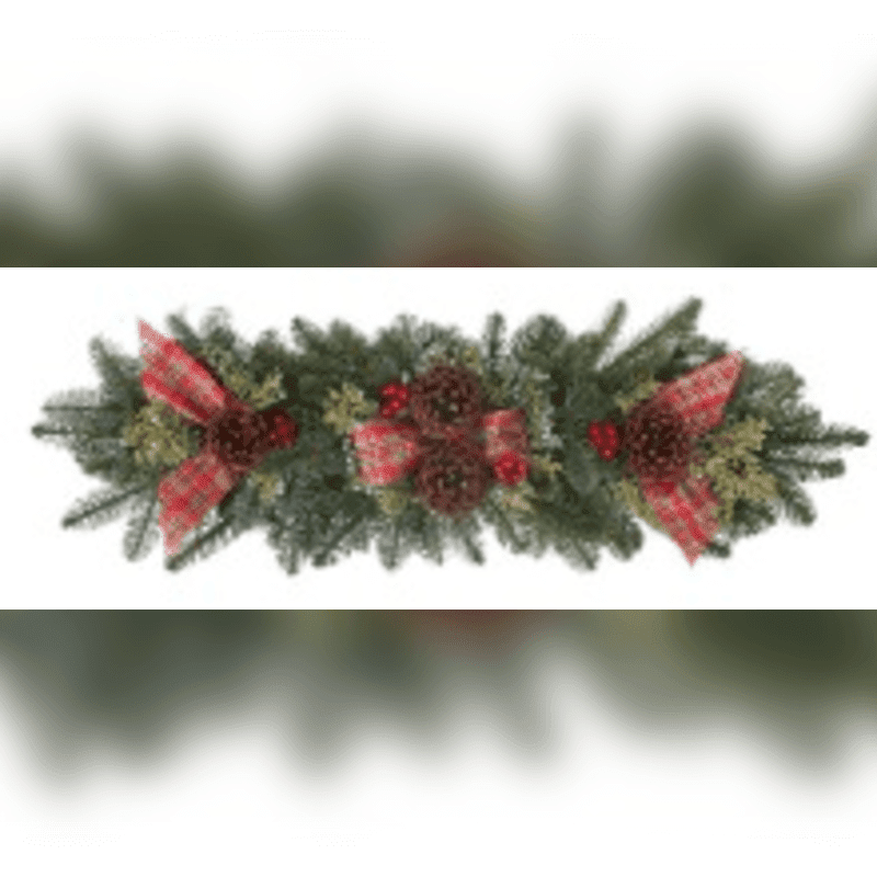 A festive evergreen garland with red plaid bows and pinecones is centered against a blurred white and grey background.