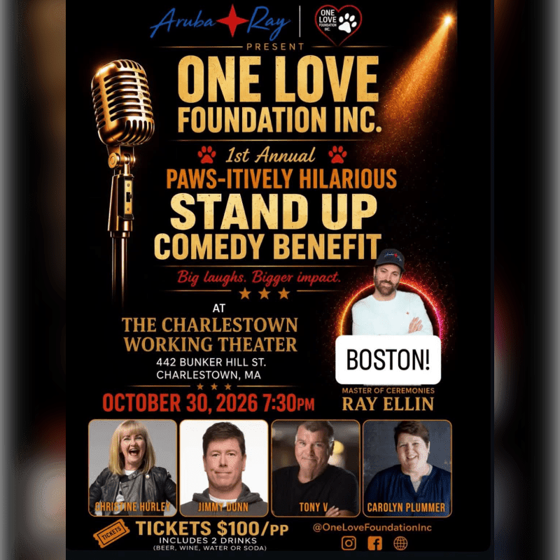 A gold vintage microphone stands in the foreground against a dark background featuring event details for a stand-up comedy benefit.