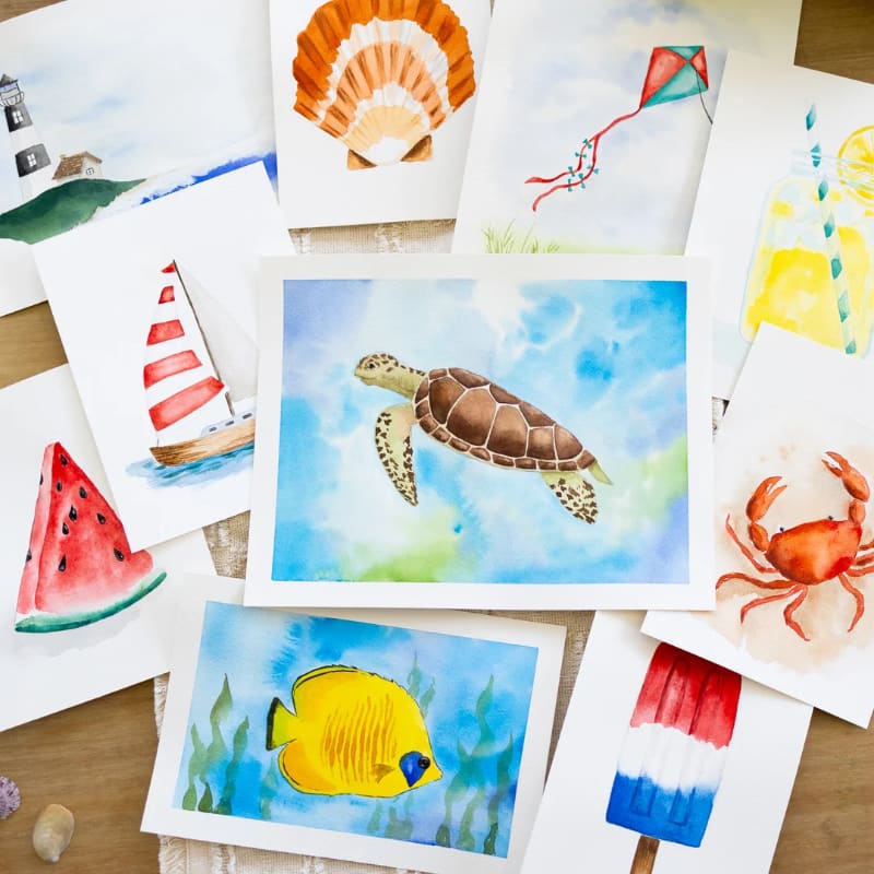 A sea turtle watercolor painting sits in the center of a scattered collection of other summer-themed watercolor artworks.