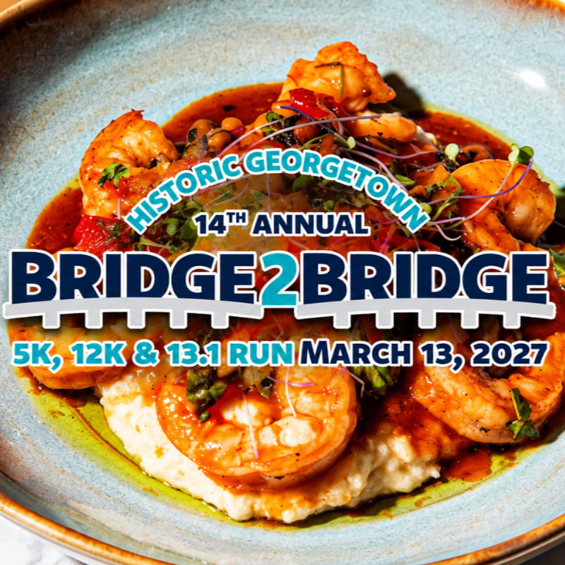 Text promoting the 14th Annual Bridge 2 Bridge run is overlaid on a foreground of shrimp and grits in a blue bowl.