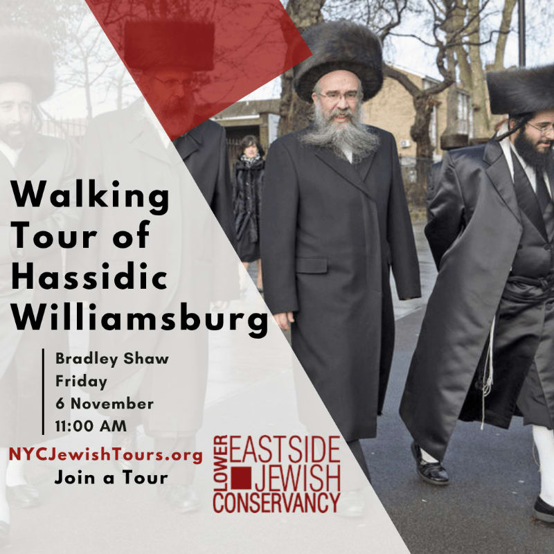 Three men in traditional Hassidic attire walk along a city sidewalk with bare trees and buildings in the background.