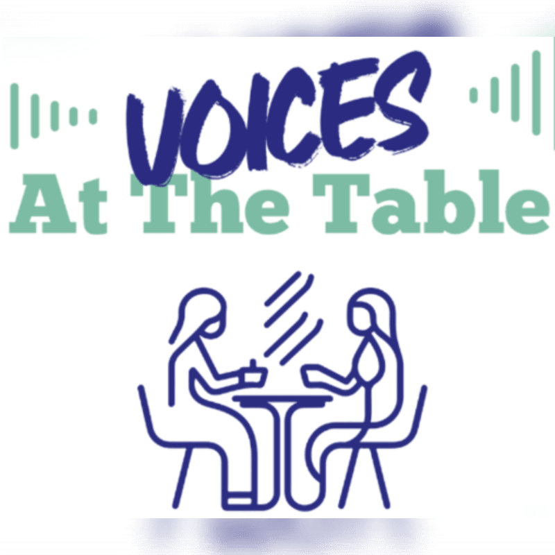 A blue line drawing of two people sitting at a table is positioned below the text "VOICES At The Table" against a plain white background.