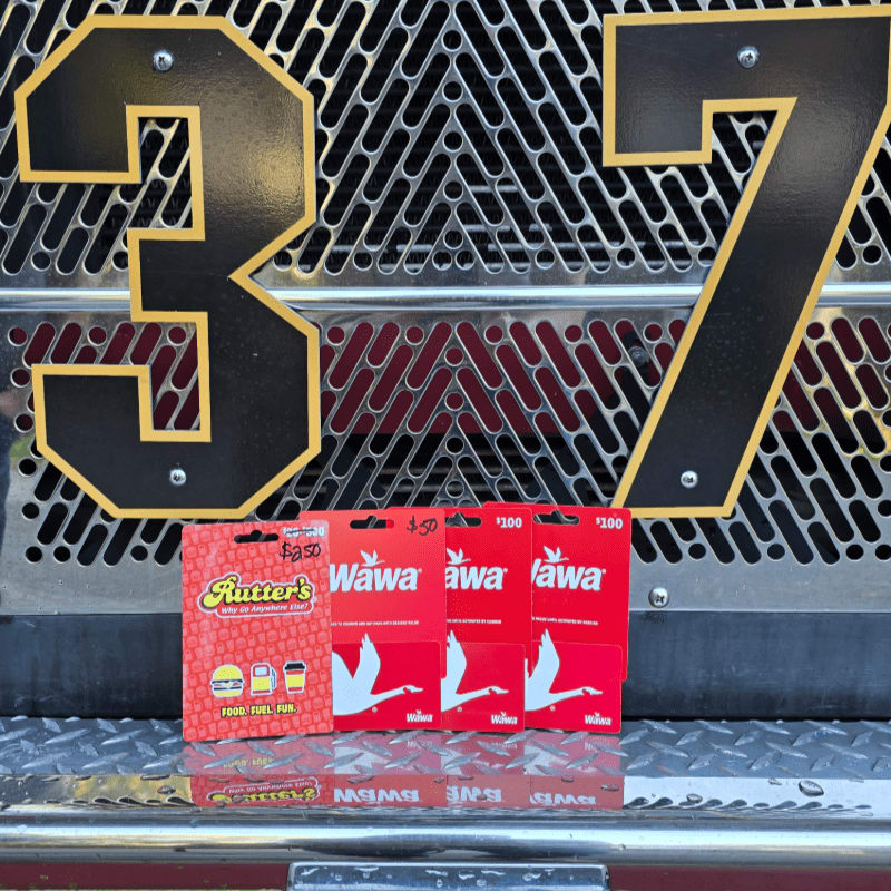 Several red Rutter's and Wawa gift cards sit on a metallic surface in front of a black mesh background featuring the numbers 3 and 7.