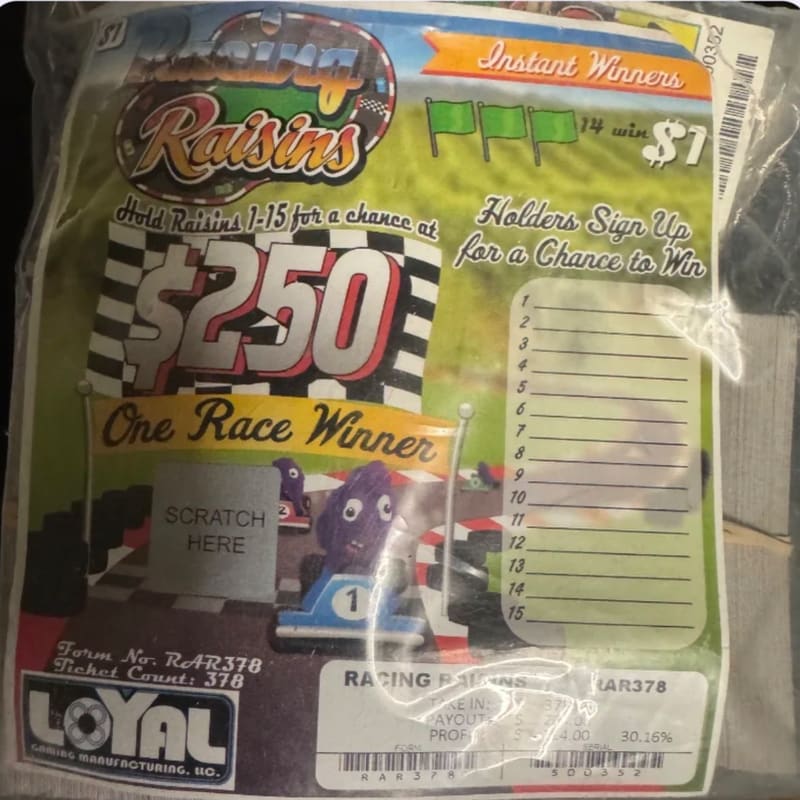 A "Racing Raisins" lottery ticket featuring a purple raisin in a race car in the foreground against a green grassy background with a sign for a $250 prize.