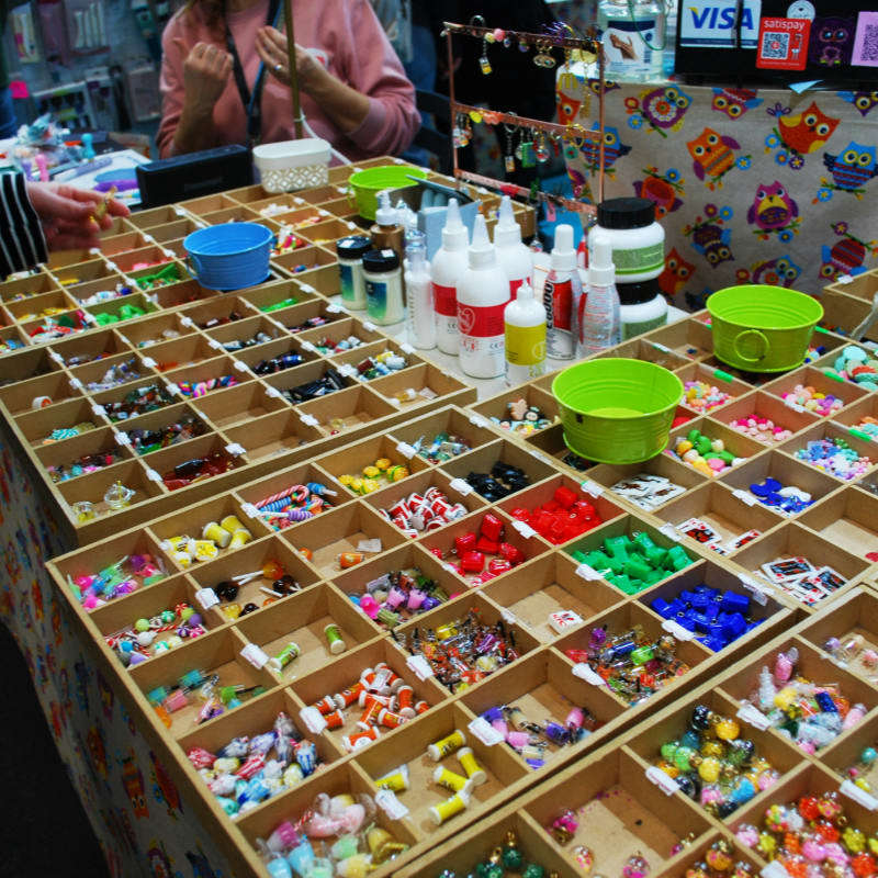 A woman standing at a table covered in lots of crafting supplies