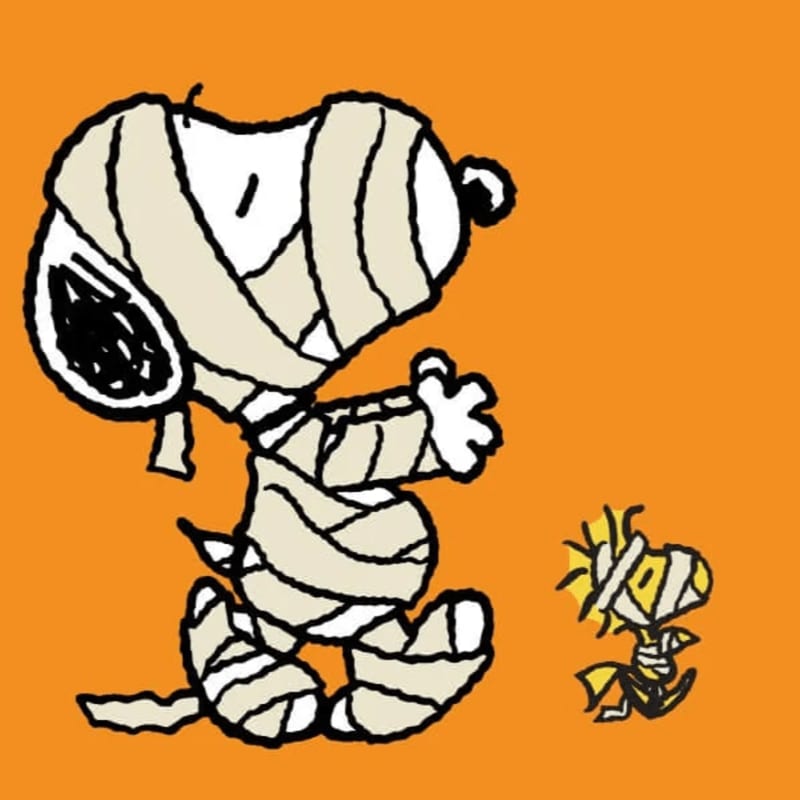 A large mummy-wrapped Snoopy stands next to a tiny mummy-wrapped Snoopy against a solid orange background.