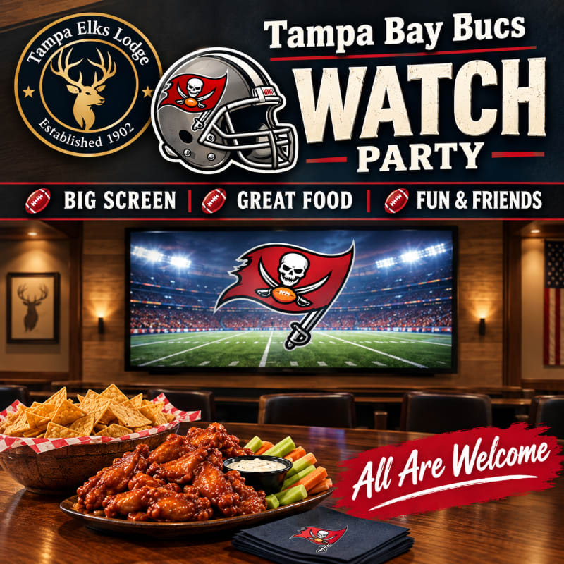 Platters of wings and chips sit in the foreground of a room featuring a large screen displaying the Tampa Bay Buccaneers logo.
