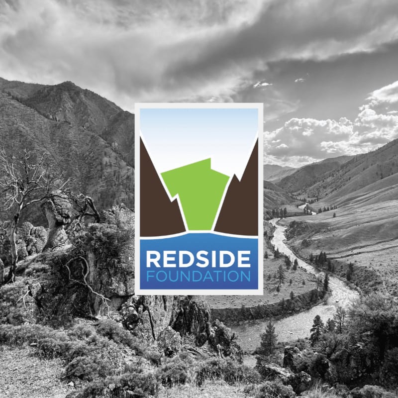 A colorful Redside Foundation logo is centered in the foreground against a black and white background of a mountainous valley and river.