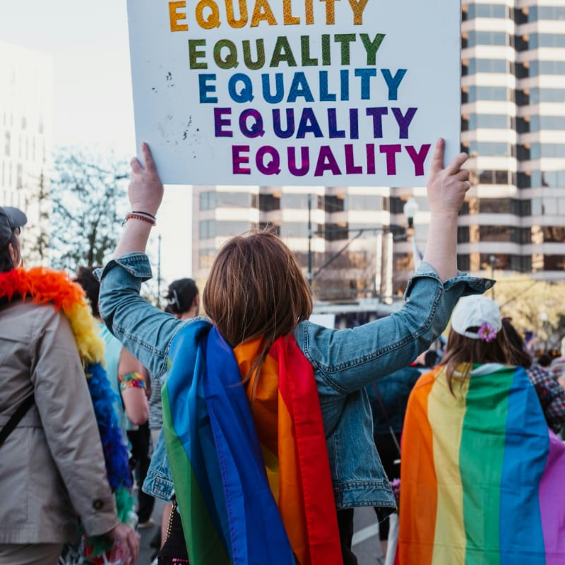 a group of people walking down a street holding a sign