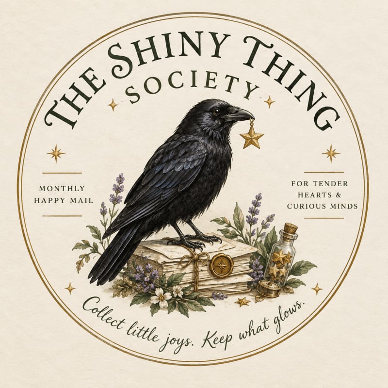 A black crow holding a gold star in its beak stands atop a stack of old books and flowers, all enclosed within a circular gold frame with elegant typography on a cream background.
