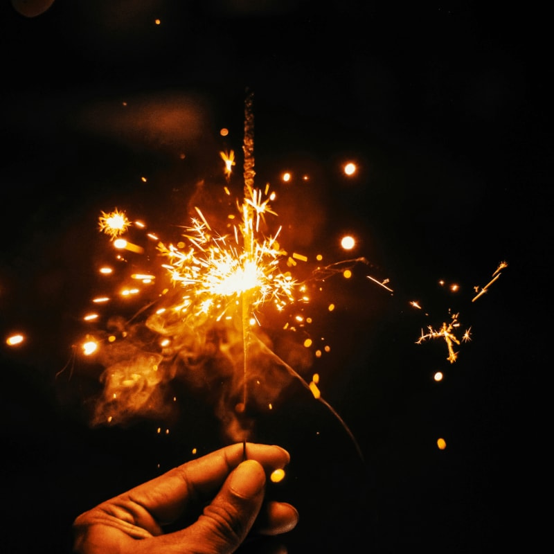 a hand holding a sparkler in the dark