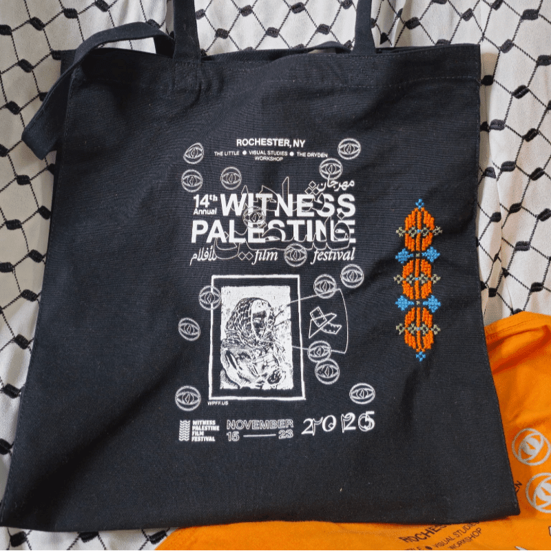 A black tote bag with white text and graphics for the "14th Annual Witness Palestine Film Festival" rests on a white and black patterned fabric.